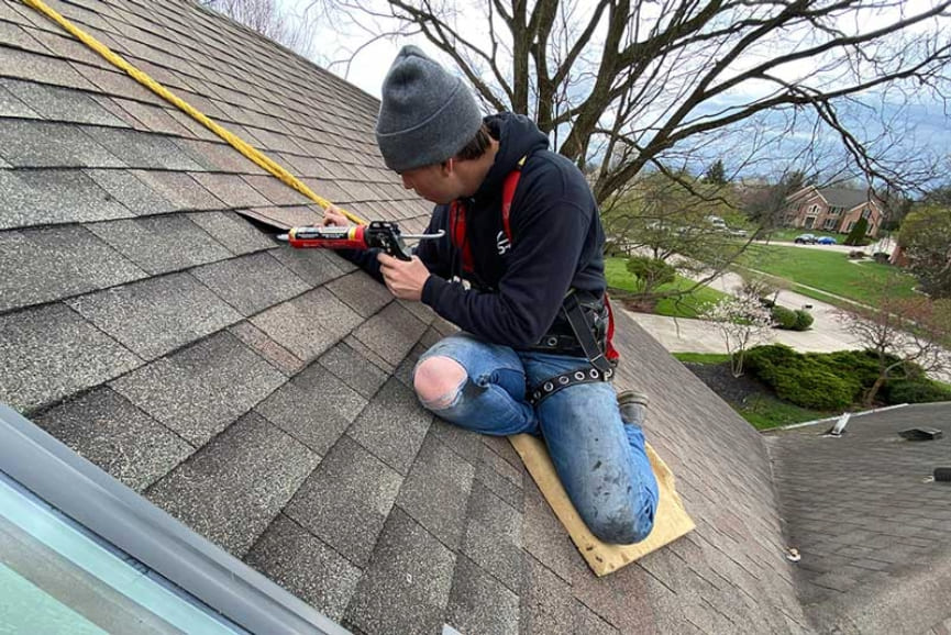 Roofer taking measurements on residential roof